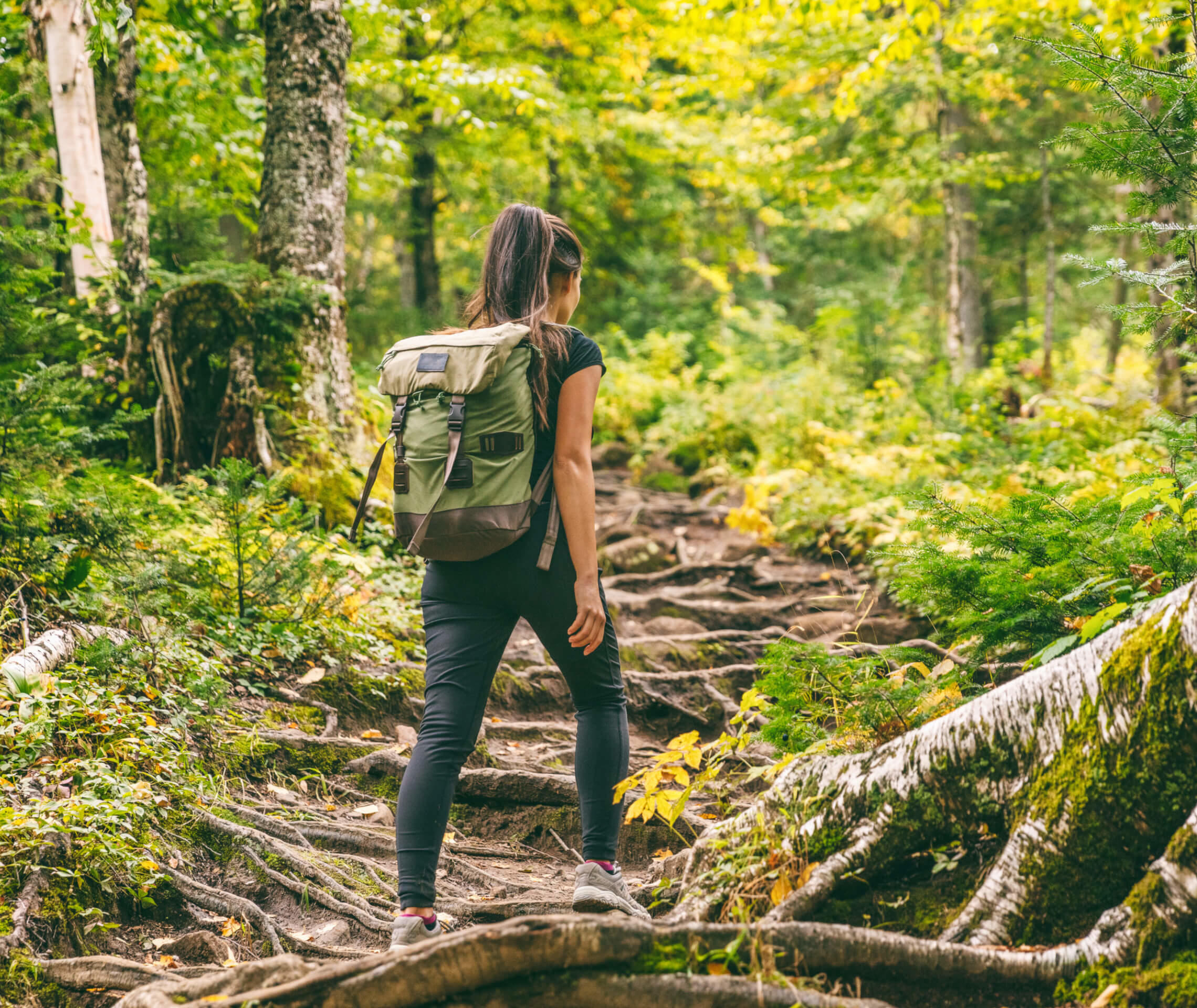 Frau macht Pause von Migräne und Familie und geht im Wald spazieren.