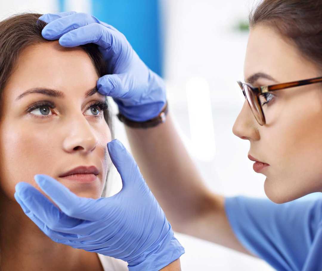 Frau wird von Ärztin hinsichtlich einer Augenmigräne untersucht.