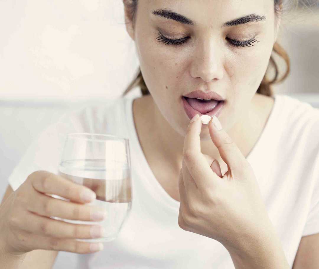 Eine Frau nimmt Triptane gegen ihre Migräne.