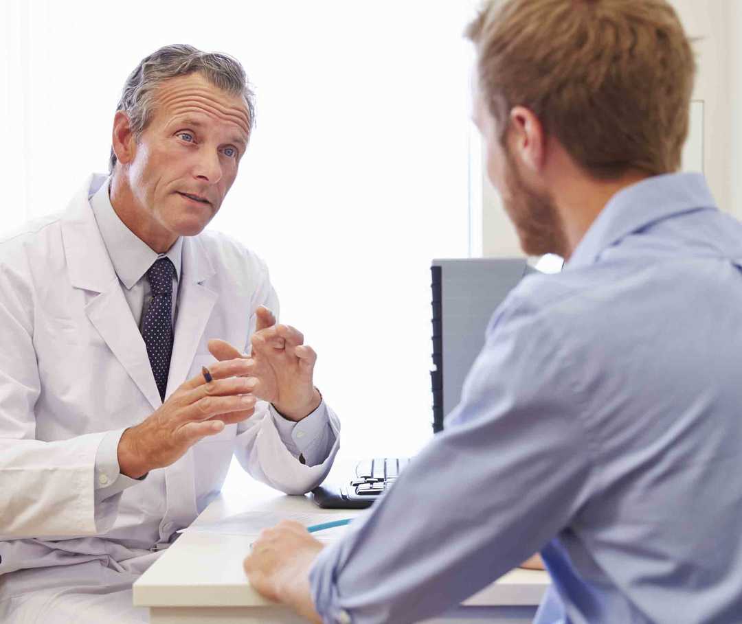 Junger Mann im Gespräch mit einem Migräne-Arzt.