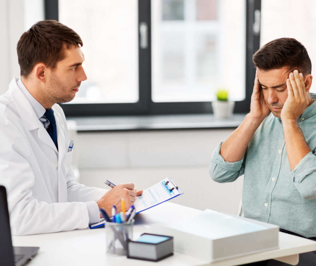 Arzt klärt Mann mit Sexualkopfschmerzen darüber auf, was er dagegen tun kann.