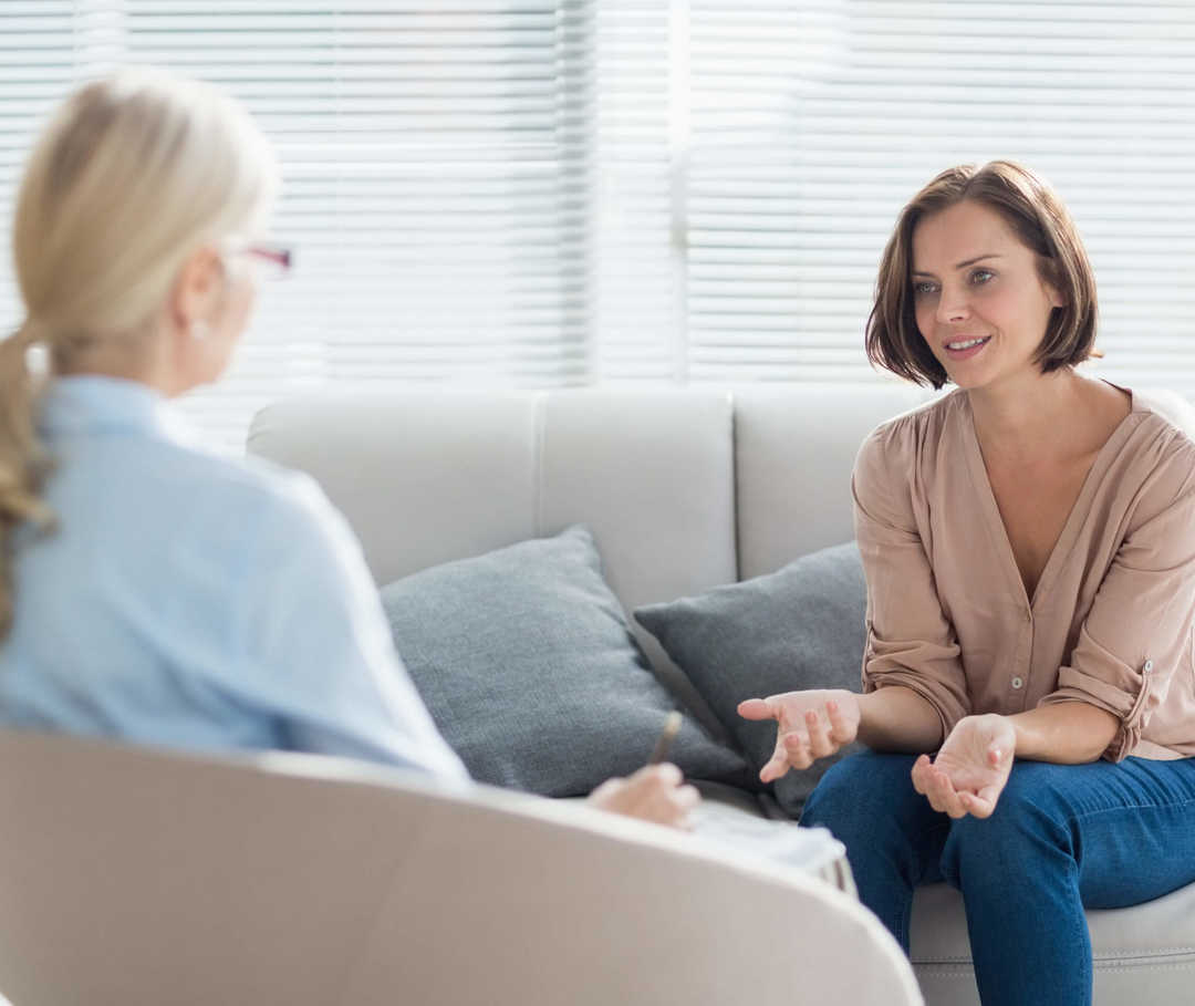 Zwei Frauen im Gespräch zur Psychotherapie bei Migräne.