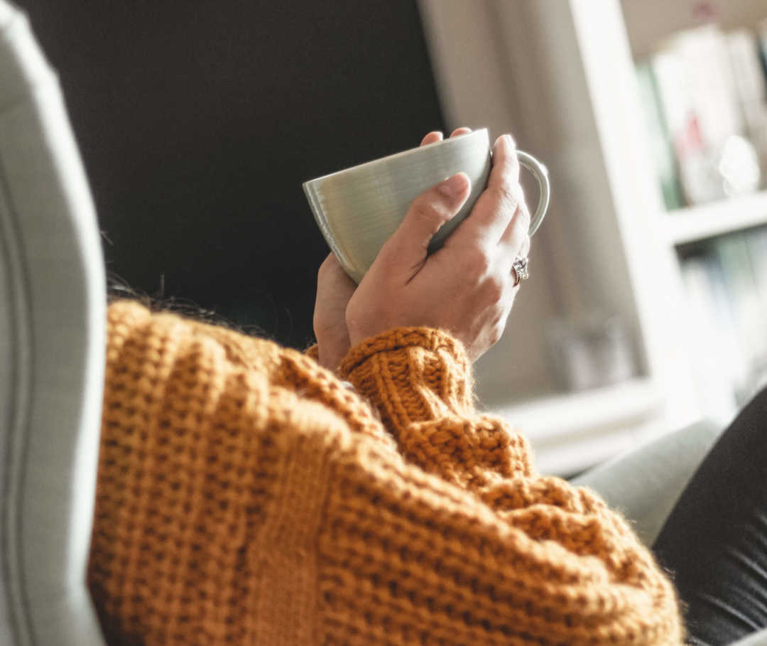 Frau entspannt mit Tasse Tee nach Psychotherapie bei Migräne.