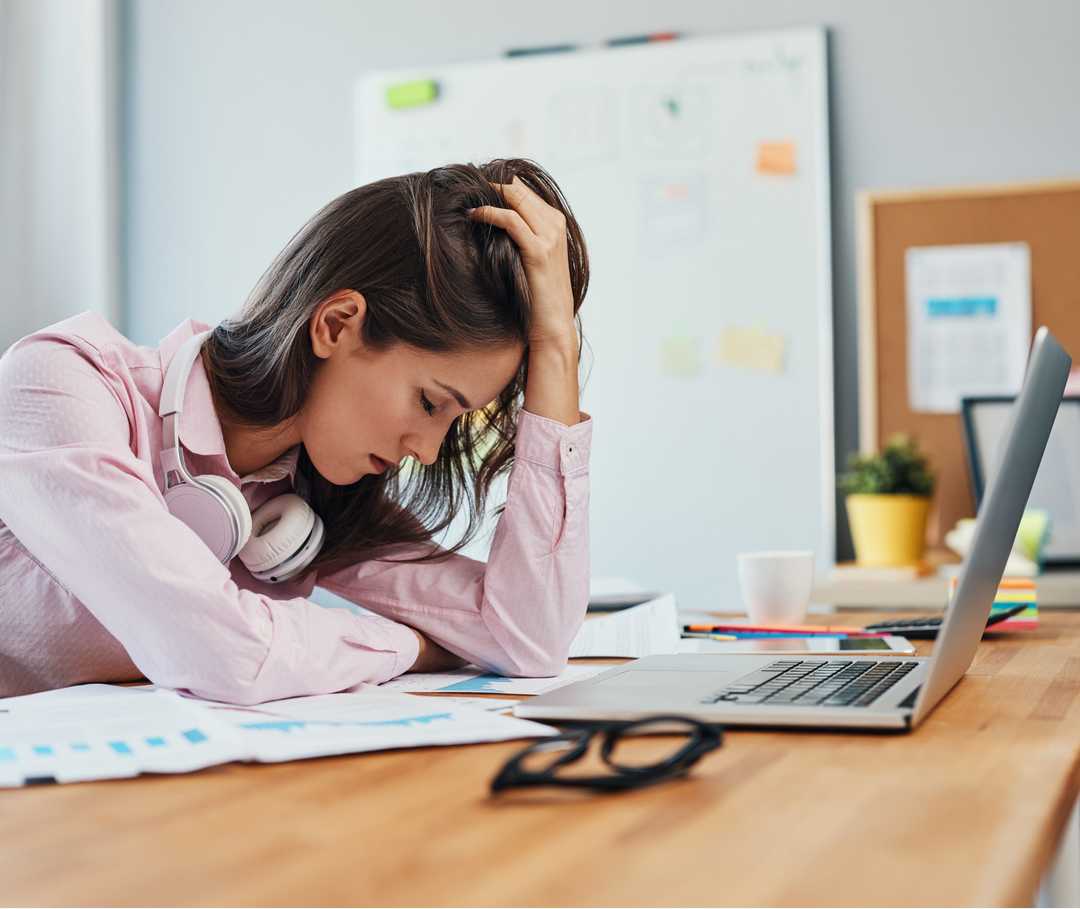 Junge Frau leidet im Homeoffice während Corona unter Migräne.