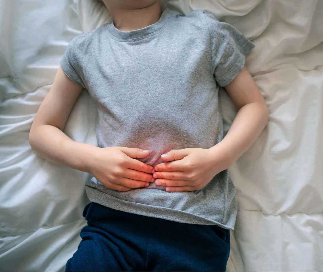 Kind leidet unter einer Bauchmigräne und liegt im Bett. Kind leidet unter einer Bauchmigräne und liegt im Bett.