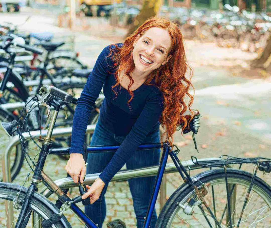 Frau mit Fahrrad: Regelmäßiger aerober Sport beugt einer Migräne vor. Frau mit Fahrrad: Regelmäßiger aerober Sport beugt einer Migräne vor.