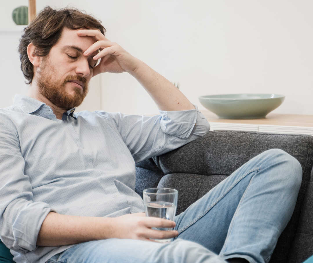 Mann ruht sich aus, nachdem er Magnesium bei Migräne eingenommen hat.