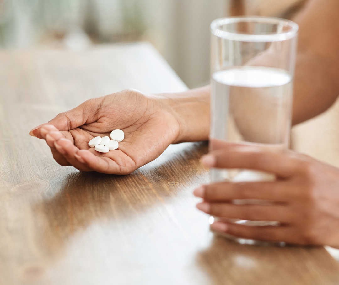 Frau hält Magnesium-Tabletten in der Hand, die ihr bei Migräne helfen sollen.
