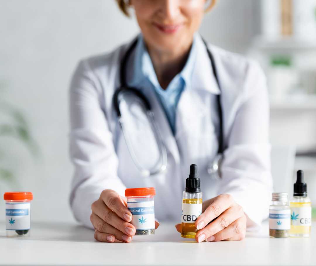 Ein Mann hält ein braunes Fläschchen mit einer Pipette in den Händen