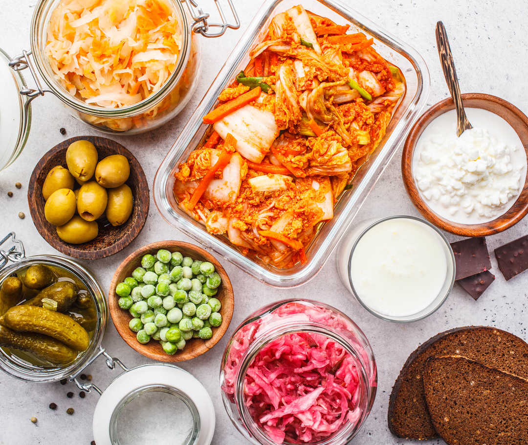Migräne und Darm Lebensmittel, die gesund für den Darm sind, darunter Kimchi, Sauerkraut und Hüttenkäse.